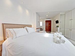 um quarto com uma grande cama branca com toalhas em Casita de la Suerte em Medina-Sidonia