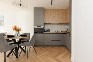 a kitchen and dining room with a table and chairs at Warsaw City Life Apartment Bagno by Renters in Warsaw