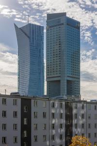 two tall buildings in a city with buildings at Warsaw City Life Apartment Bagno by Renters in Warsaw