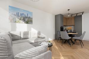 a living room with a white couch and a table at Warsaw City Life Apartment Bagno by Renters in Warsaw