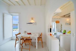 a white dining room with a white table and chairs at Villa Princess 1 4Bed with Pool Panormos Beach in Panormos Mykonos