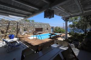 a patio with a pool and a table and chairs at Villa Princess 1 4Bed with Pool Panormos Beach in Panormos Mykonos