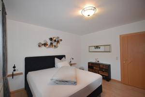 sypialnia z białym łóżkiem i drewnianą podłogą w obiekcie Hofer Stubn w mieście Kolsassberg