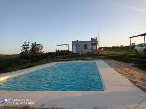 une piscine vide avec une maison en arrière-plan dans l'établissement Carabanchel, à Canepa