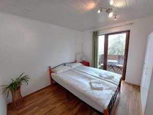 a white bedroom with a bed and a window at Countryside Apartment Agnes in Šentjošt nad Horjulom