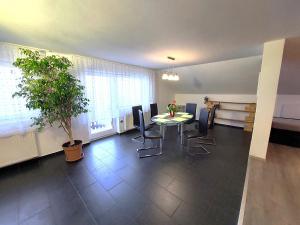 a dining room with a table and chairs and a plant at Countryside Apartment Agnes in Šentjošt nad Horjulom