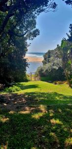 a grass field with a view of the ocean at Black Rock Haven in Scottburgh