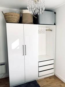 a white cabinet in a room with a chandelier at Stylish city flat with private parking in Bristol