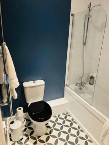 a bathroom with a black and white toilet and a shower at Stylish city flat with private parking in Bristol