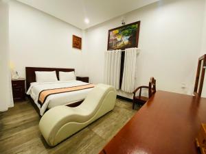 a hotel room with a bed and a table at Jen Hotel in Tuy Hoa