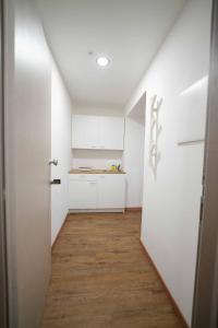 a small kitchen with white cabinets and a wooden floor at Neapolitan Soul By Dimorra in Naples