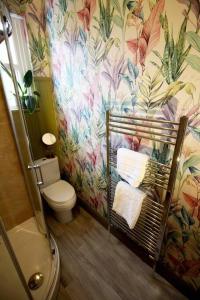 uma casa de banho com WC e papel de parede florido em Lincoln Apartment freshly renovated common views em Lincolnshire