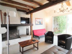 a living room with a red couch and a fireplace at Les barthes in Orist