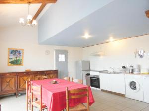 a kitchen with a table with a red table cloth at Les barthes in Orist
