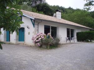 a small white house with blue doors and flowers at Les barthes in Orist