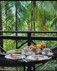 una mesa de desayuno con comida y bebida en el balcón en Eco Resort Nagual en São Pedro da Serra