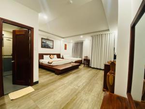 een slaapkamer met een bed en een woonkamer bij Jen Hotel in Tuy Hoa