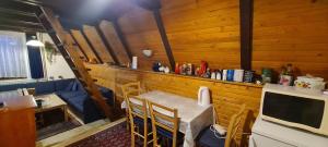 a dining room with a table and a tv at Vjeverica Chalet in Jahorina