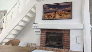 a fireplace in a living room with a picture on the wall at Villa 16 personnes à 50m plage Sud in Lacanau +17 photos