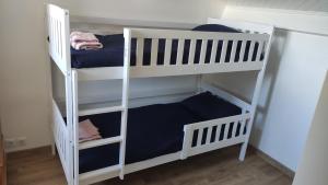 two white bunk beds in a room at Villa 16 personnes à 50m plage Sud in Lacanau
