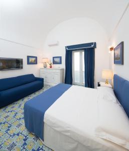 1 dormitorio con 1 cama grande y 1 sofá azul en Marlin Guest House, en Capri