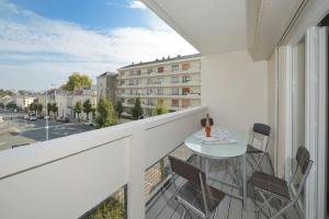 a balcony with a table and chairs and a building at Le New Yorkais-Jardin des Plantes in Angers