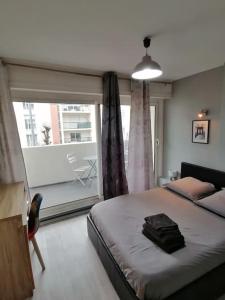 a bedroom with a bed and a large window at Le New Yorkais-Jardin des Plantes in Angers