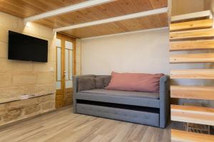 een woonkamer met een bank en een flatscreen-tv bij Harbour View Lofts in Senglea