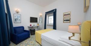 1 dormitorio con 1 cama y 1 silla azul en Marlin Guest House, en Capri