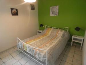 una camera con un letto con una parete verde di Gite de spalette a Orthevielle