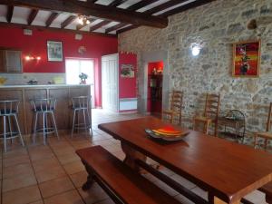 un soggiorno con tavolo in legno e una cucina di Gite de spalette a Orthevielle