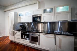 een keuken met witte kasten en roestvrijstalen apparatuur bij Enter Tromsø Ultimate Luxury - Jacuzzi & Sauna in Tromsø