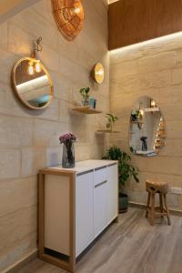 een badkamer met een witte wastafel en een spiegel bij Harbour View Lofts in Senglea