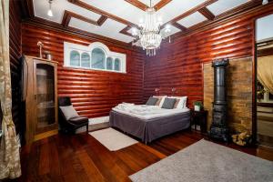 een slaapkamer met houten wanden, een bed en een kroonluchter bij Enter Tromsø Ultimate Luxury - Jacuzzi & Sauna in Tromsø