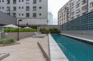 a swimming pool in the middle of a city with buildings at Predio completo com piscina perto de estacao de metro no centro de SP - Setin Downtown Praca da Se in Sao Paulo