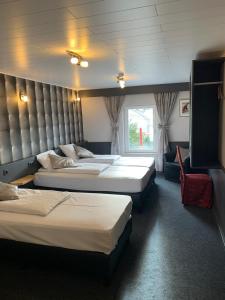 een hotelkamer met 3 bedden en een raam bij RAVeL Hotel Cyrano in Waimes