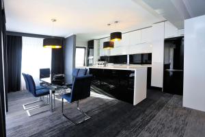 a kitchen with a dining table and blue chairs at Carpe Diem Boutique Hotel in Zenica