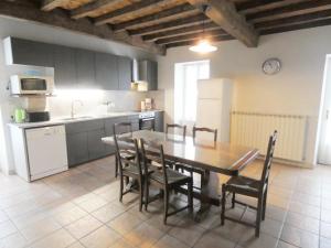 a kitchen with a wooden table and chairs in a room at Le tuc in Orist +11 photos