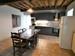 a kitchen with a table and chairs and a refrigerator at Le tuc in Orist