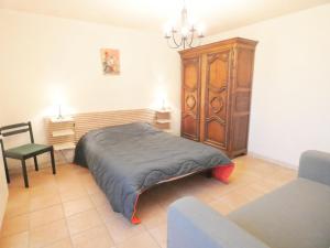 a bedroom with a bed and a wooden cabinet at Le tuc in Orist