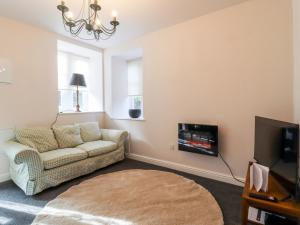 a living room with a couch and a tv at The Stables in Colne