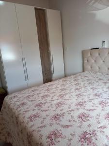 una camera da letto con un letto con copriletto rosa floreale di Lar do Sossego a Paraty