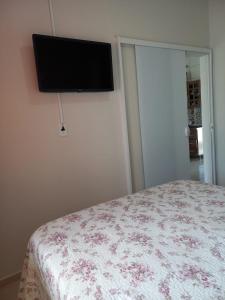 a bedroom with a bed and a flat screen tv on the wall at Lar do Sossego in Paraty