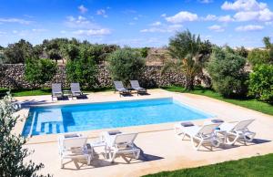 - une piscine avec des chaises longues et un bouquet de chaussons dans l'établissement Masseria Specchia, à Lecce