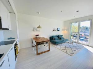 a living room with a blue couch and a table at Lakeside Modern Minimalist Apartment FreeParking in Järvenpää