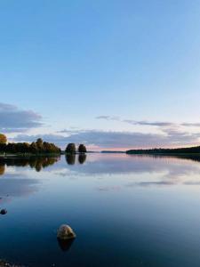 a large lake with a rock in the middle at Lakeside Modern Minimalist Apartment FreeParking in Järvenpää