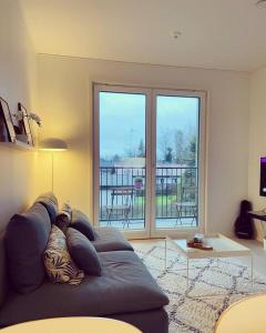 a person laying on a couch in a living room at Lakeside Modern Minimalist Apartment FreeParking in Järvenpää