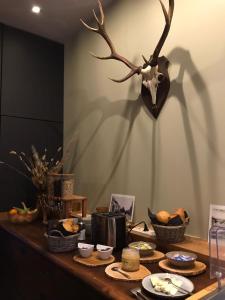 une table avec de la nourriture sur elle et des bois sur le mur dans l'établissement Ma Bauge, à Libin