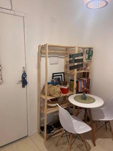 a room with a table and chairs and a shelf at Loft no coração da Lapa in Rio de Janeiro
