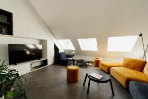 een woonkamer met een bank en een tv bij Befour Vakantiewoning in Aalst